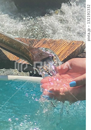Fresh Water Flowing Into Hands from Metal Pipe Outdoors 132191332