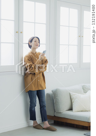 リビングでスマホを見る女性 132191480