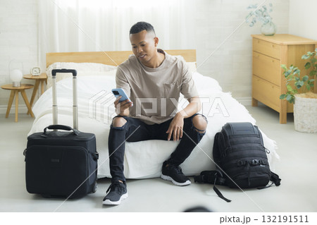 ホテルの客室でスマホを見る外国人の男性  132191511