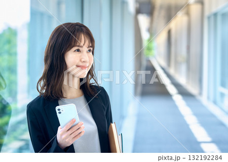 廊下でスマホを持つ若いビジネスウーマン 廊下でスマホを持つ若いビジネスウーマン 132192284