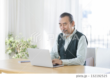 ノートパソコンで作業をする70代の男性 132192525