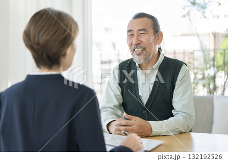 ビジネスウーマンと向き合って話をするシニア男性 132192526