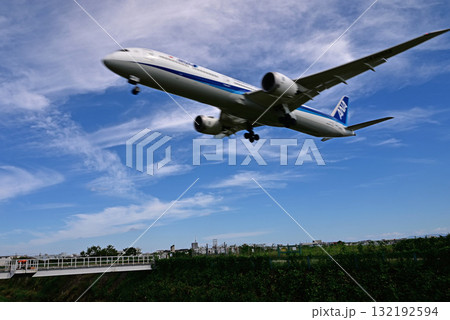豊中市の千里川上を飛び去る旅客機 豊中市の千里川上を飛び去る旅客機 132192594