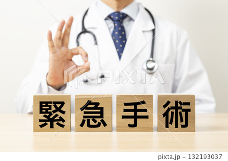 「緊急手術」と書かれたブロックとOKサインをする医師 「緊急手術」と書かれたブロックとOKサインをする医師 132193037