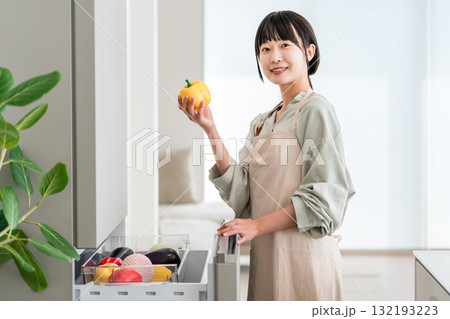冷蔵庫の野菜室から野菜を出す女性,主婦,家政婦,家事代行 132193223