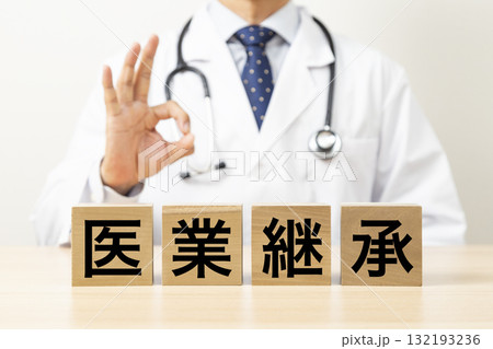 「医業継承」と書かれたブロックとOKサインをする医師 132193236