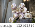 Bunch of garlic bulbs resting on wooden surface 132193819
