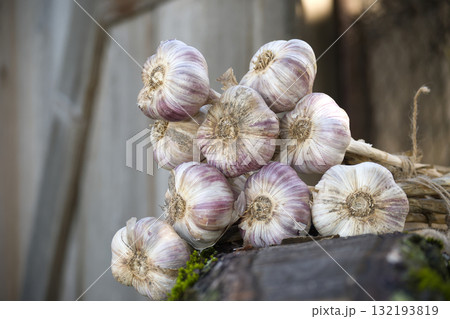 Bunch of garlic bulbs resting on wooden surface 132193819