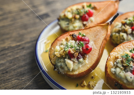 Delicious baked pears with nuts, blue cheese, thyme, cranberry and honey 132193933