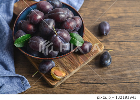 Ripe plums in blue bowl Ripe plums in blue bowl 132193943