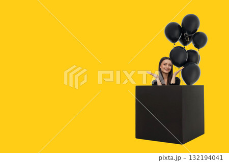 Cheerful woman with long hair in a black box with balloons 132194041