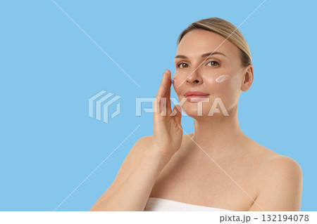 Woman soothing her skin with cream in a light atmosphere Woman soothing her skin with cream in a light atmosphere 132194078