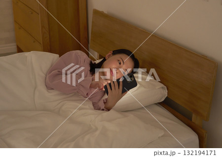 布団の中でスマホを見る女性 布団の中でスマホを見る女性 132194171