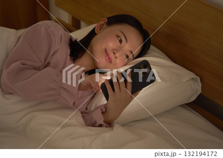 布団の中でスマホを使う女性 布団の中でスマホを使う女性 132194172