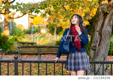 紅葉を背に休憩する女子高生 冬服で通学する高校生 登校下校  紅葉を背に休憩する女子高生 冬服で通学する高校生 登校下校  132194209