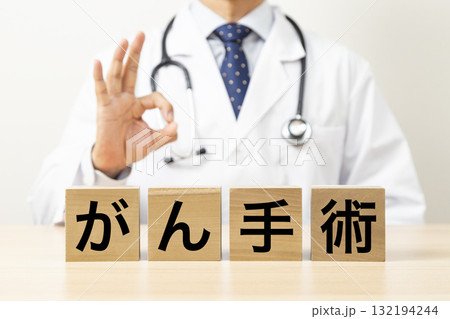 「がん手術」と書かれたブロックとOKサインをする医師 132194244