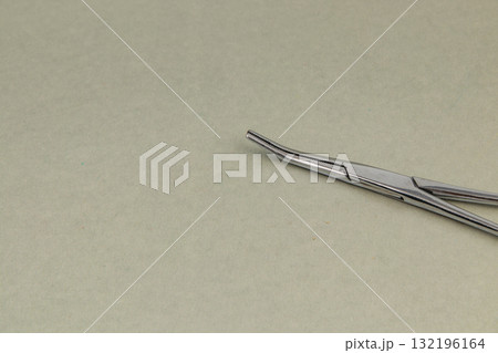 Tweezers placed on a light surface for precise tasks in a workspace 132196164