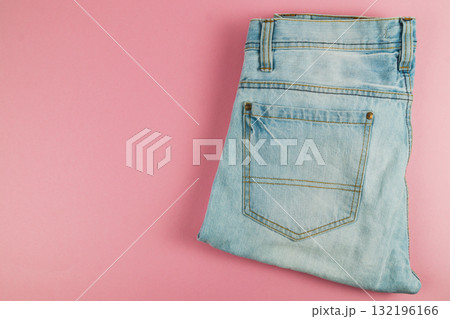 Stylish folded denim jeans on a pink background ready for casual wear 132196166