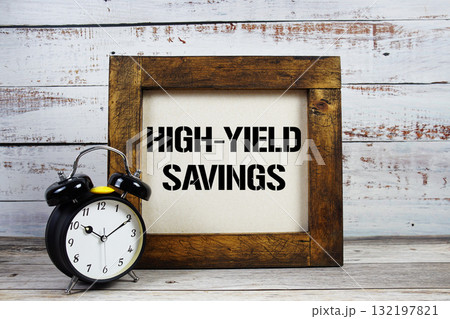 High-Yield Savings text with alarm clock on wooden background High-Yield Savings text with alarm clock on wooden background 132197821