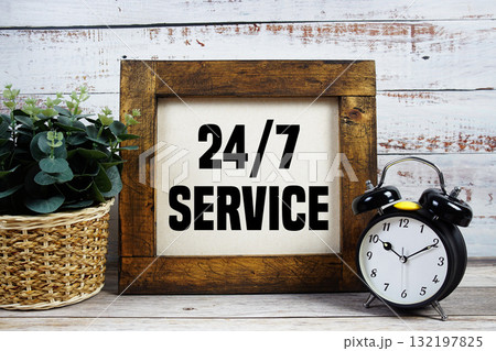 24 Hr. 7 Day Service text with alarm clock on wooden background 24 Hr. 7 Day Service text with alarm clock on wooden background 132197825