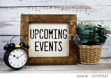Upcoming Events text with alarm clock on wooden background 132197827
