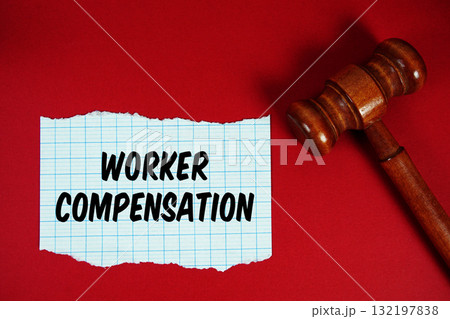 Worker Compensation text written on rip paper with wooden judgment gavel on red background Worker Compensation text written on rip paper with wooden judgment gavel on red background 132197838