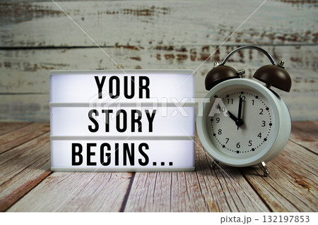 Your Story Begins... text with alarm clock on wooden background Your Story Begins... text with alarm clock on wooden background 132197853