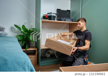 Man assembling wooden cabinet. DIY home furniture project 132199061