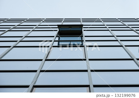 Glass facade of modern building with open window 132199076