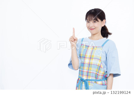 人差し指を立てるエプロン姿の主婦 132199124