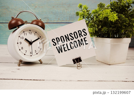 Sponsors Welcome text written on paper card with alarm clock on wooden background 132199607