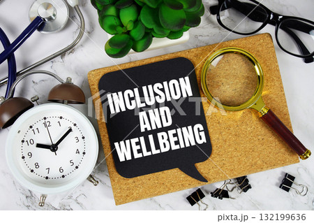 Inclusion And Wellbeing text with alarm clock, calculator and stethoscope on marble background 132199636