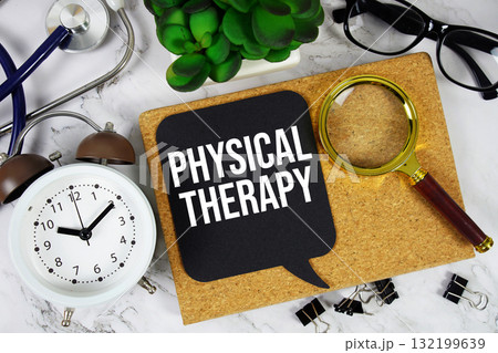 Physical Therapy text with alarm clock, calculator and stethoscope on marble background 132199639