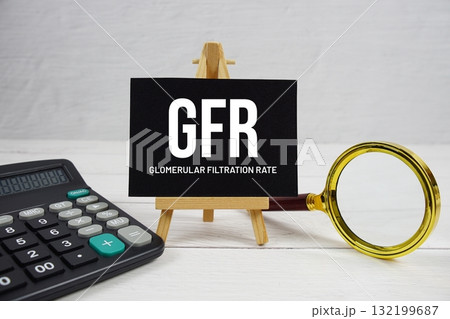 GFR abbreviation of Glomerular Filtration Rate text with magnifying glass and calculator on wooden background 132199687