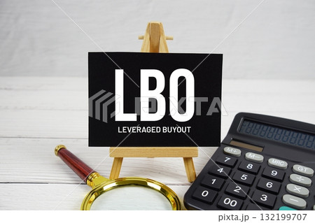LBO Leveraged Buyout text with magnifying glass and calculator on wooden background 132199707