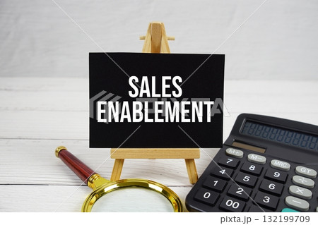 Sales Enablement text with magnifying glass and calculator on wooden background Sales Enablement text with magnifying glass and calculator on wooden background 132199709