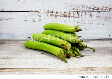 Fresh green long Thai eggplants on wooden background 132199716