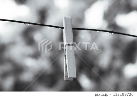 Minimalist black and white photo of a clothespin with raindrops on a wire Minimalist black and white photo of a clothespin with raindrops on a wire 132199726