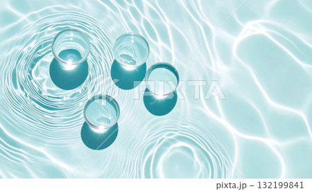 Transparent glass spheres on a blue water surface with caustic light reflections. 132199841
