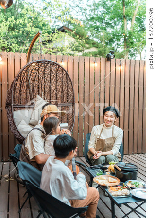 ウッドデッキで食事するファミリー（グランピング,アウトドア,別荘,コテージ） 132200396