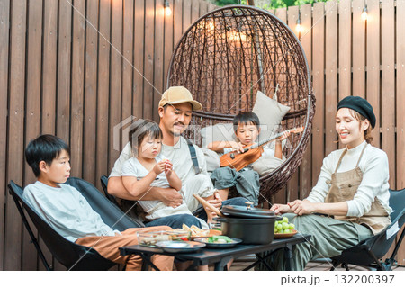ウッドデッキで食事するファミリー(グランピング,アウトドア,別荘,コテージ) ウッドデッキで食事するファミリー(グランピング,アウトドア,別荘,コテージ) 132200397