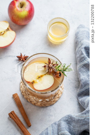 Hot apple cider with cinnamon, anise, and rosemary in glass on a light background with honey Hot apple cider with cinnamon, anise, and rosemary in glass on a light background with honey 132200788