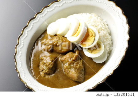 ゆで卵を乗せたチキンカレーを黒背景で撮影 132201511