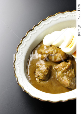 ゆで卵を乗せたチキンカレーを黒背景で撮影 132201520