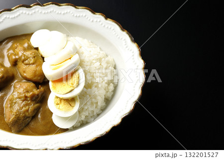 ゆで卵を乗せたチキンカレーを黒背景で撮影 132201527