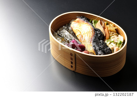 曲げわっぱに入っていて銀鱈の西京焼が乗っている海苔弁当を黒背景で撮影 132202187