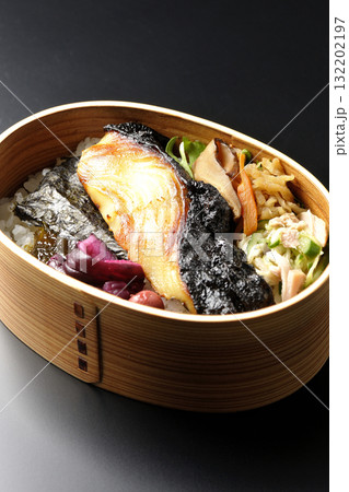 曲げわっぱに入っていて銀鱈の西京焼が乗っている海苔弁当を黒背景で撮影 132202197