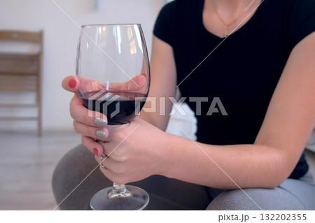 Woman with a glass of red wine in her hands, hands close-up. Woman with a glass of red wine in her hands, hands close-up. 132202355