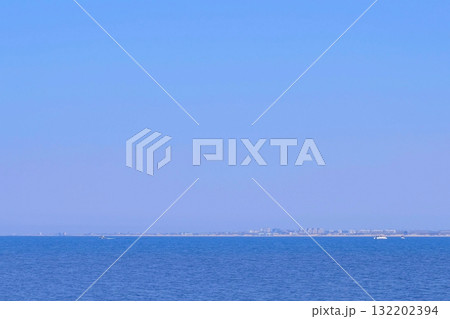 Seascape background with blue water, yachts, city on distance and clear sky. 132202394