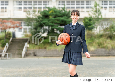 バスケットボールを持って校庭に立つ制服姿の高校生,中学生,小学生の女の子 バスケットボールを持って校庭に立つ制服姿の高校生,中学生,小学生の女の子 132203424